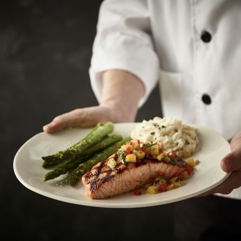 Bonefish Grill - a chef holding a plate of food - Seafood Near Me - Brooksville, Florida Bonefish Grill - a chef holding a plate of food - Seafood Near Me - Brooksville, Florida