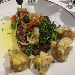 Grilled octopus entree with spinach and grilled potatoes.