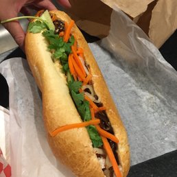 a person's hand holding a sub sandwich a person's hand holding a sub sandwich