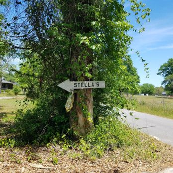 Stella's Place - a street sign on a tree stump - Barbeque Near Me - Milton, Florida