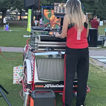 Boston Common - A woman DJ is playing music outdoors in a park, using DJ equipment and a laptop, with speakers set up on either side. - Parks Near Me - Boston, Massachusetts