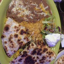 Steak quesadilla - The image shows a plate with quesadillas, rice, a side salad, and sour cream, served on a green tray.