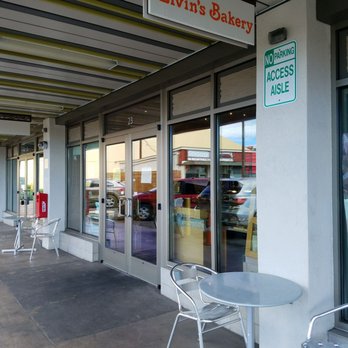 Elvin's Bakery - Entrance area of Elvin's Bakery. There are two tables with chairs outside. No seating inside.......it's basically grab & go. - Bakeries Near Me - Honolulu, Hawaii