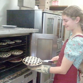 Shakespeare Pies - a woman putting pies into an oven - Desserts Near Me - Shakespeare, Ontario Shakespeare Pies - a woman putting pies into an oven - Desserts Near Me - Shakespeare, Ontario