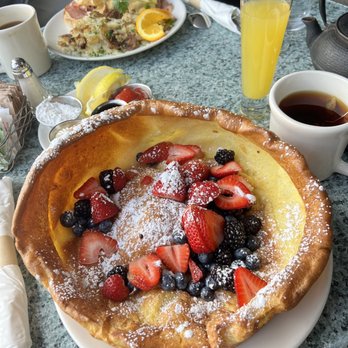 Plums Cafe - Dutch baby pancake with berries and mimosa - Breakfast & Brunch Near Me - Costa Mesa, California Plums Cafe - Dutch baby pancake with berries and mimosa - Breakfast & Brunch Near Me - Costa Mesa, California