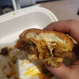  a hand holding a half eaten sandwich