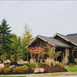 Simms Landscape - A balanced front yard design that mixes lush greenery and natural stone for a warm welcome.