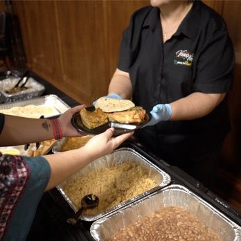 Ventura's Tamales - Ventura's Tamales serving someone at a catered event. - Tex-Mex Near Me - Victoria, Texas