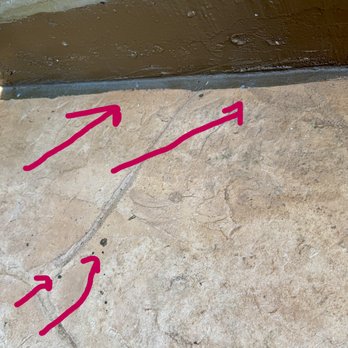 Erics Home Renovation - Stain at the base of the steps, where the steps meet the concrete and random drops of stain  on the concrete patio. - General Contractors Near Me