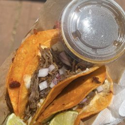a pulled pork taco in a paper bag