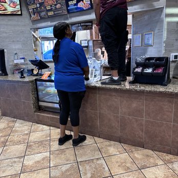 Golden Chick - Employee standing on counter where food is picked up. - Fast Food Near Me - Abilene, Texas
