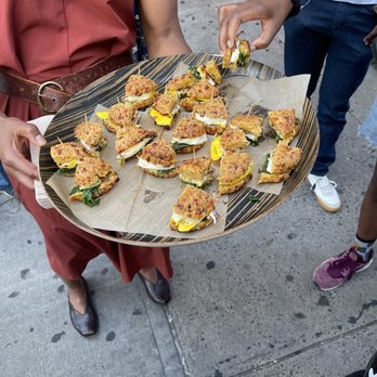 The Boogie Down Grind - a woman holding a tray of food - Coffee & Tea Near Me - Bronx, New York