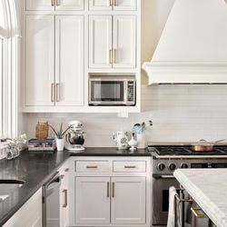 Lake Austin kitchen with cabinets painted in Sherwin Williams "Greek Villa", walls in "Neutral Ground", island in "Iron Ore"