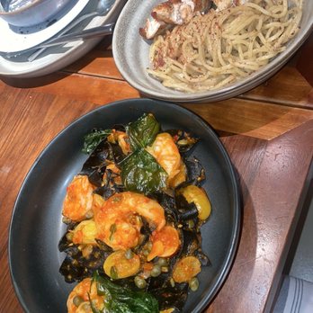 Sofia - Squid ink pasta with shrimp (dark grey bowl)  Cacio e Pepe add chicken (light grey bowl) - Italian Near Me - New Orleans, Louisiana