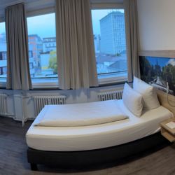 Stadthotel Kassel - Das schmale Einzelbett steht frei im Raum, die Lage zum Hinterhof ist ruhig.