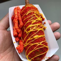 Corn dog topped with hot Cheetos