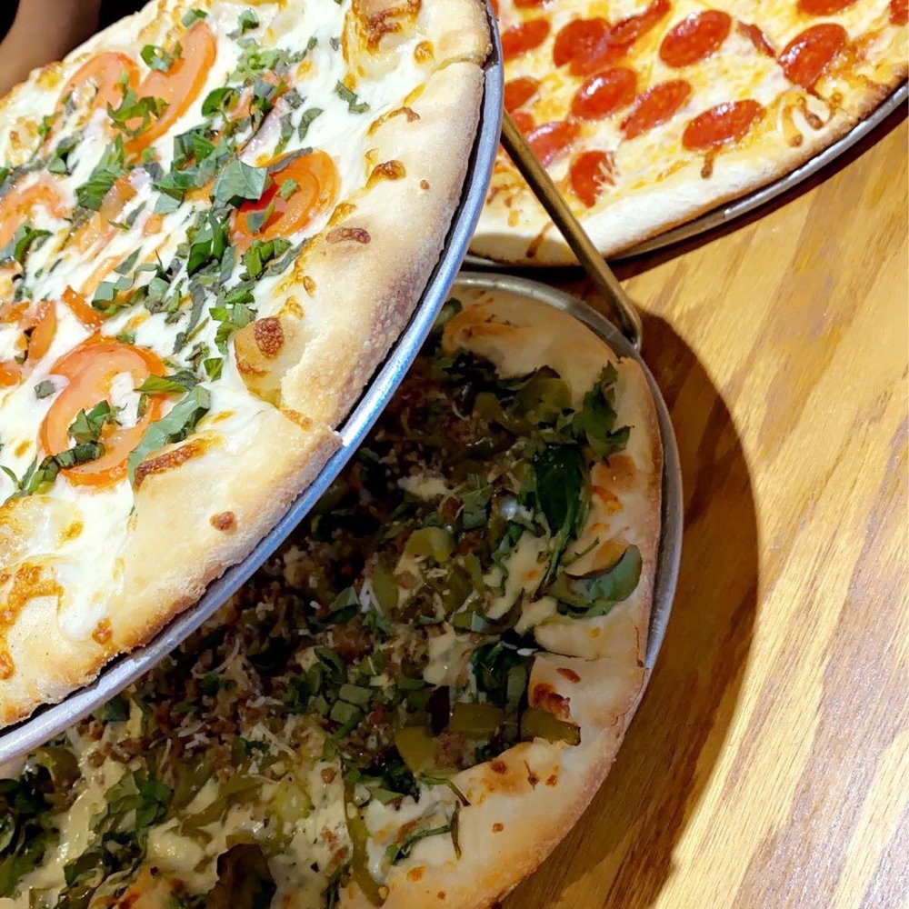Pizza Bella - three different pizzas on a table - Pizza Near Me - Katy, Texas