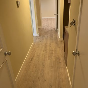 Glorious Flooring - a long hallway with light wood floors - Flooring Near Me