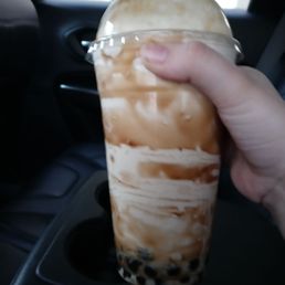a hand holding a cup of iced coffee a hand holding a cup of iced coffee