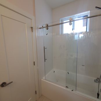 Blacklotus Renovations - a bathroom with a glass shower door - General Contractors Near Me