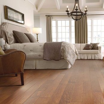 Inspired Floors - a bedroom with a large bed and a chandelier - Carpet Installation Near Me - Missouri City, Texas
