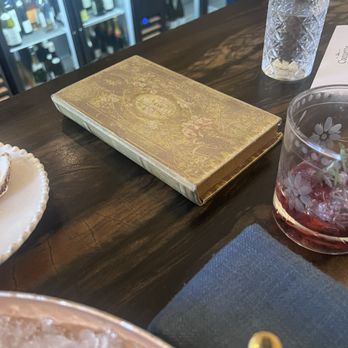 Coquette - The classic book "Receipt Holder" along with the "Black Rose" drink. - Patisserie/Cake Shop Near Me - Charlotte, North Carolina Coquette - The classic book "Receipt Holder" along with the "Black Rose" drink. - Patisserie/Cake Shop Near Me - Charlotte, North Carolina