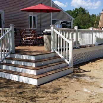 Albee Contracting - a deck with a table and chairs and an umbrella - General Contractors Near Me Albee Contracting - a deck with a table and chairs and an umbrella - General Contractors Near Me