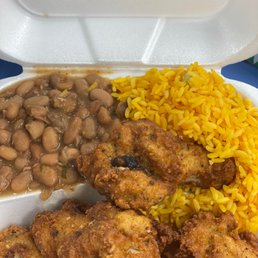 a plate of fried chicken, rice and beans