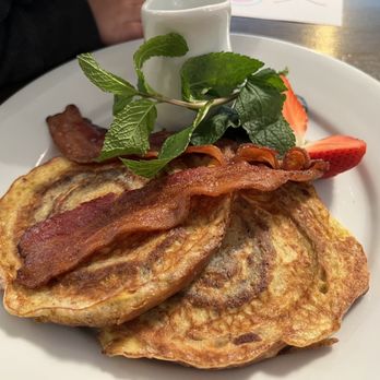 Le Café Entre Amis - a plate of pancakes with bacon and strawberries - Canadian (New) Near Me - Montebello, Quebec Le Café Entre Amis - a plate of pancakes with bacon and strawberries - Canadian (New) Near Me - Montebello, Quebec