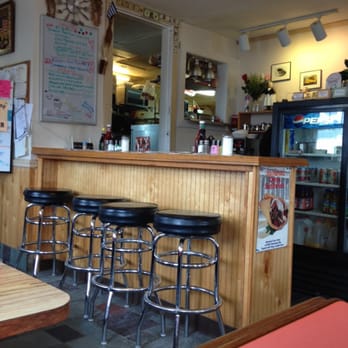 Cosmos Restaurant - a bar with stools and a refrigerator - New American Near Me - Salisbury, Massachusetts
