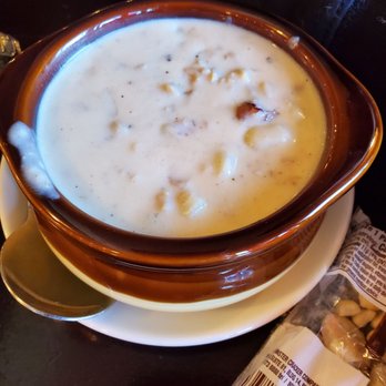 Tempesta's - Clam chowder - A bowl of clam chowder with a creamy texture and visible chunks of clams, served in a brown ceramic bowl on a white plate. - American Near Me - Keene, New Hampshire