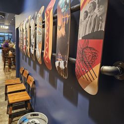 Social Tap - Skateboards mounted on the wall outside of the bathrooms