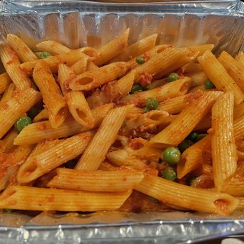 Cafe Amici - Penne Vodka - A serving of penne pasta with a tomato-based sauce, mixed with green peas and small bits of meat, presented in a disposable aluminum foil container. The pasta appears cooked and coated evenly with the sauce, suitable for takeout or casual dining. - Italian Near Me - Hamden, Connecticut