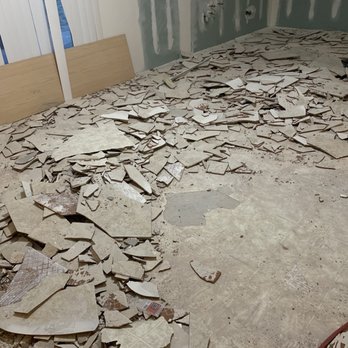 Junk Grabberz - Before picture of Kitchen area with broken tile. - Junk Removal & Hauling Near Me