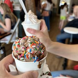 Vanilla Bean Custom Ice Cream and Coffee - Chocolate base with rainbow sprinkles and chocolate sauce (slightly melted), Vanilla base with fruit mix-ins in the background