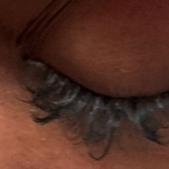 Self Care Studio - A detailed close-up of a person's closed eye, highlighting the eyelashes, eyelid, and surrounding skin. The skin texture and natural features are visible, with the eyelashes appearing slightly curled and the eyelid relaxed. - Eyelash Service Near Me - Brooklyn, New York