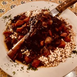 Sophie's Bistro - New Zealand lamb shank braised in a port wine reduction served over Israeli couscous with carrots, mushrooms and onions
