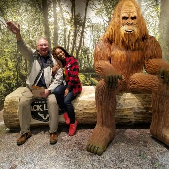 Jack Link's Wild Side - a man and a woman sitting on a log with a bigfoot statue in the background - Specialty Food Near Me - Minneapolis, Minnesota