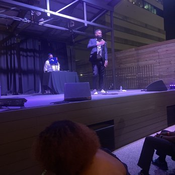 The Belmont - a man standing on a stage with a microphone - Music Venues Near Me - Austin, Texas The Belmont - a man standing on a stage with a microphone - Music Venues Near Me - Austin, Texas