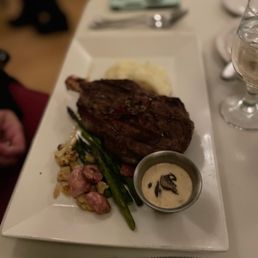 Grilled 18 oz ribeye served with mashed potatoes, grilled vegetables & mushroom brandy cream sauce