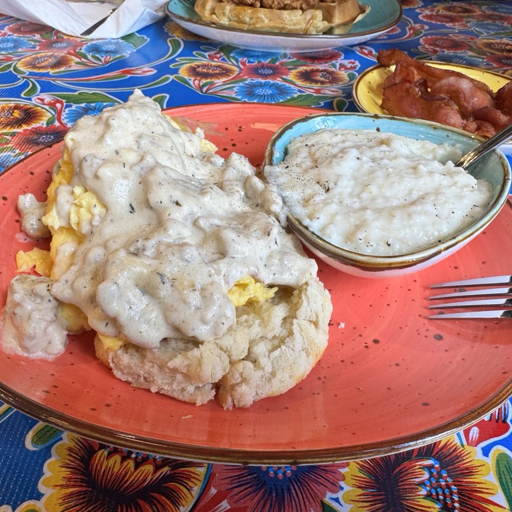 Flying Biscuit Cafe - Biscuit, eggs, and gravy with grits and a side of bacon. - Breakfast & Brunch Near Me - Mobile, Alabama Flying Biscuit Cafe - Biscuit, eggs, and gravy with grits and a side of bacon. - Breakfast & Brunch Near Me - Mobile, Alabama