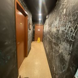 Back hallway full of things written in chalk. Where the bathrooms are.