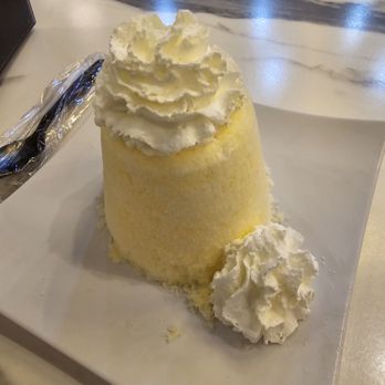 Vampire Penguin - Orange Dreamscapade - A snow dessert with finely shaved ice, topped with whipped cream, is presented on a white plate in a dessert shop setting. - Ice Cream & Frozen Yogurt Near Me - Brandon, Florida