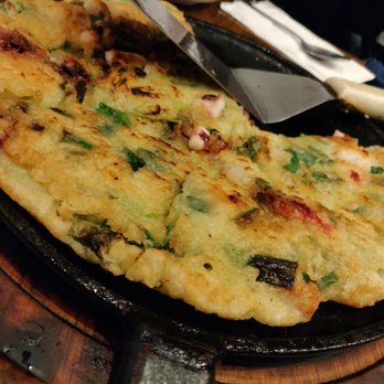 Doma - Seafood Pajeon. Comes on a sizzling platter, crunchy on the outside, tender on the inside. Filled with squid and green onion. - Korean Near Me - Sunnyside, New York Doma - Seafood Pajeon. Comes on a sizzling platter, crunchy on the outside, tender on the inside. Filled with squid and green onion. - Korean Near Me - Sunnyside, New York