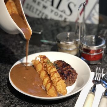 MOMO CURRY - sauce being poured over a plate of food - Japanese Curry Near Me - New York, New York