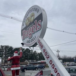 a man in a santa suit fixing a bagel sign