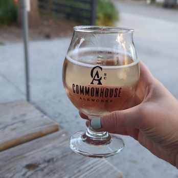 Commonhouse Aleworks - a hand holding a glass of ale - Breweries Near Me - North Charleston, South Carolina