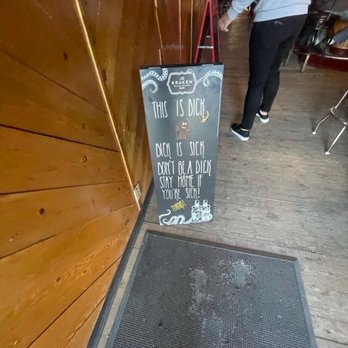 Shelly's Cowboy Bar - a man walking past a sign - Bars Near Me - Afton, Wyoming