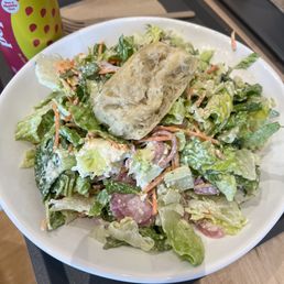 a plate of salad and a can of soda