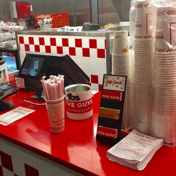 Five Guys - a red counter with cups and paper straws - Burgers Near Me - Arlington, Virginia Five Guys - a red counter with cups and paper straws - Burgers Near Me - Arlington, Virginia